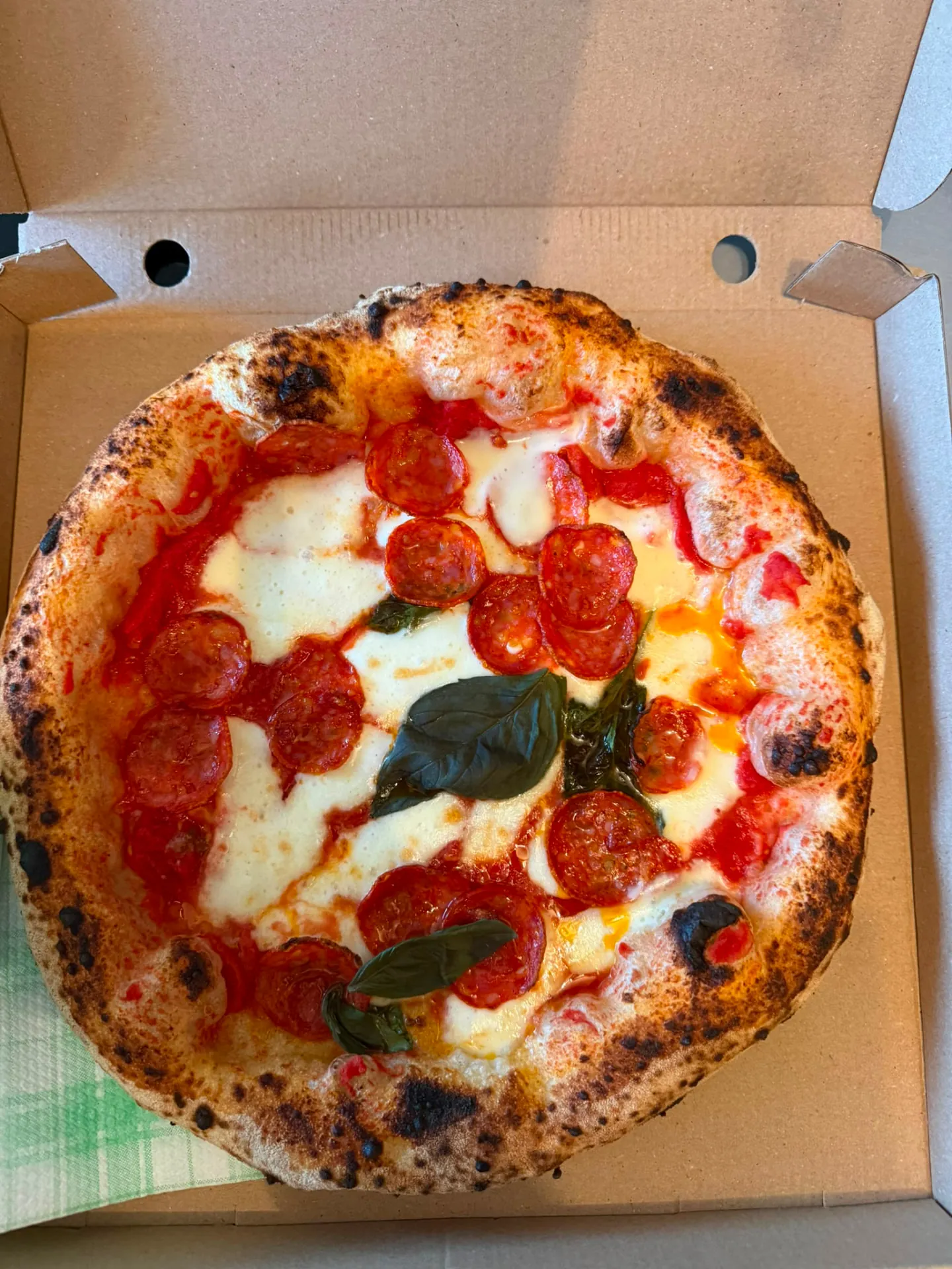 Wood-fired pepperoni and basil pizza from Spagnapoli in Roldán