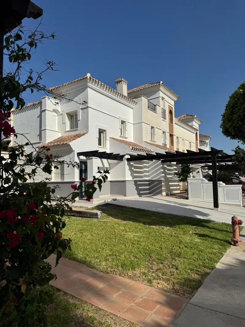 Casa Sylvia front garden with manicured planting and townhouse facade in warm sunlight